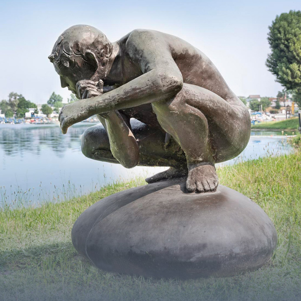 Scultura di un uomo accovacciato in posizione pensante presente all'Idroscalo