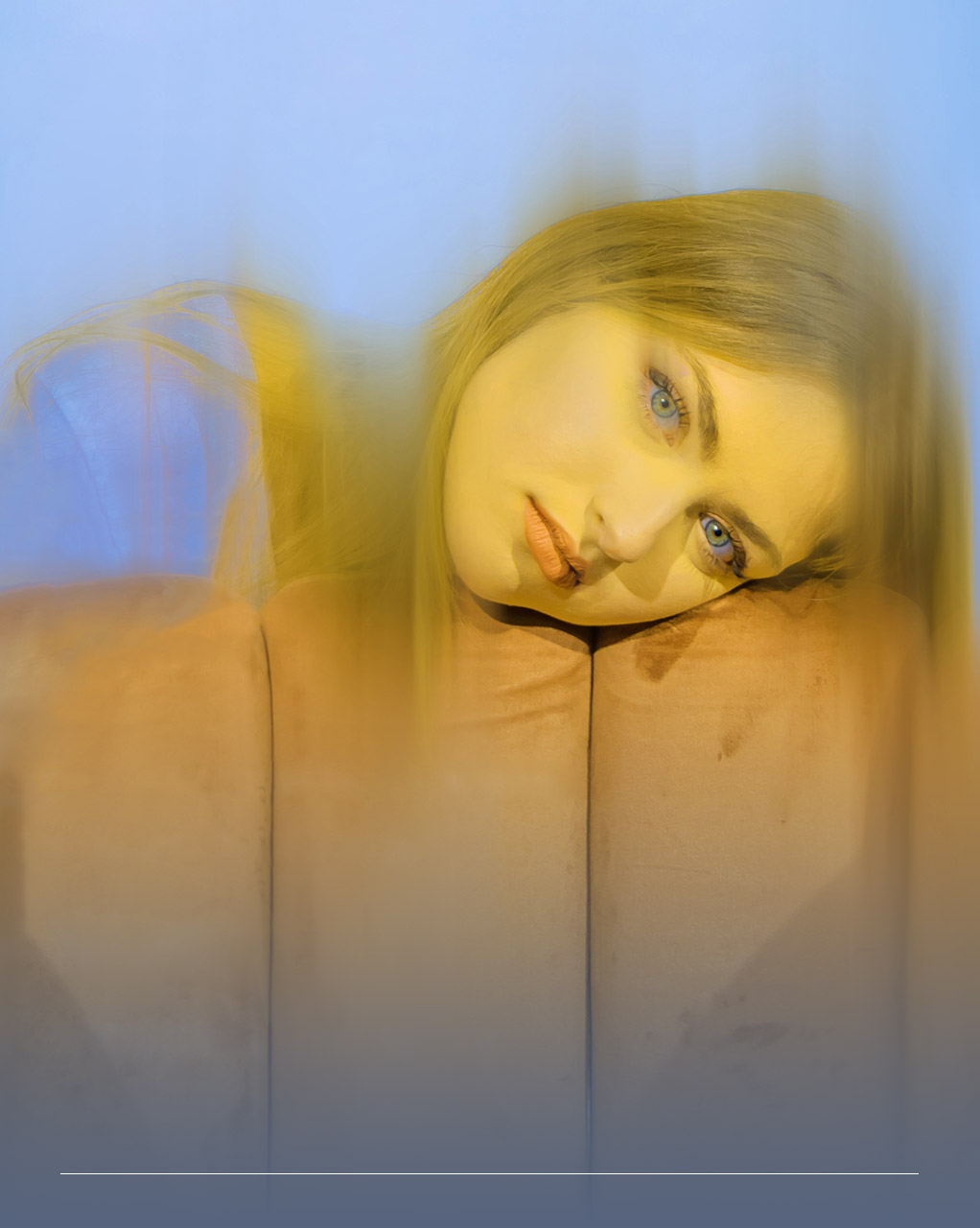Fotografia con un effetto sbiadito raffigurante il volto di una giovane donna appoggiato su un divano
